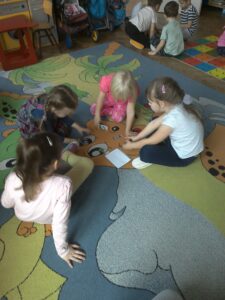Na zdjęciu widać cztery dziewczynki rozwiązujące zagadki.