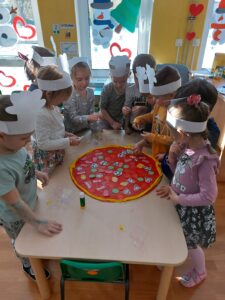 Dzieci dekorują pizze składnikami 