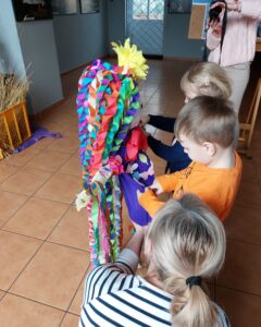 Dzieci ubierały marzanne w kolorową sukienkę z bibuły 