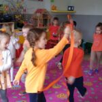 Taniec dzieci z pomarańczową wstążką.