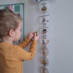 Chłopiec zaznacza na tablicy plan dnia.