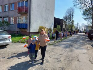Przedszkolaki uczestniczą w pochodzie ulicami miasta
