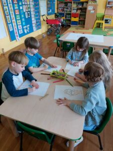 Przedszkolaki malują obrazek dłoni z puzzlami 
